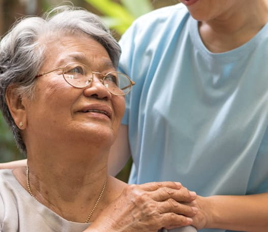 A woman showing compassion to an elderly woman who is speaking