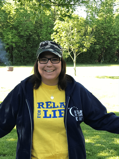 Dianne standing outside wearing a Relay for Life shirt and hoodie.