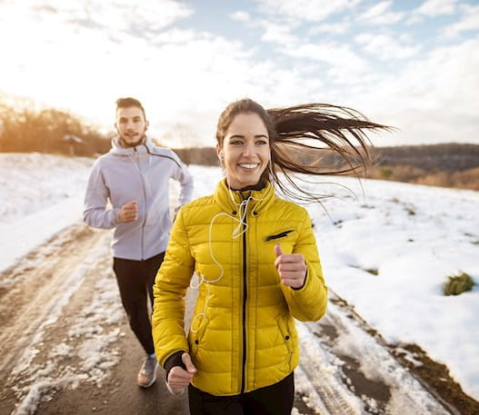 A man and a women running outdoors